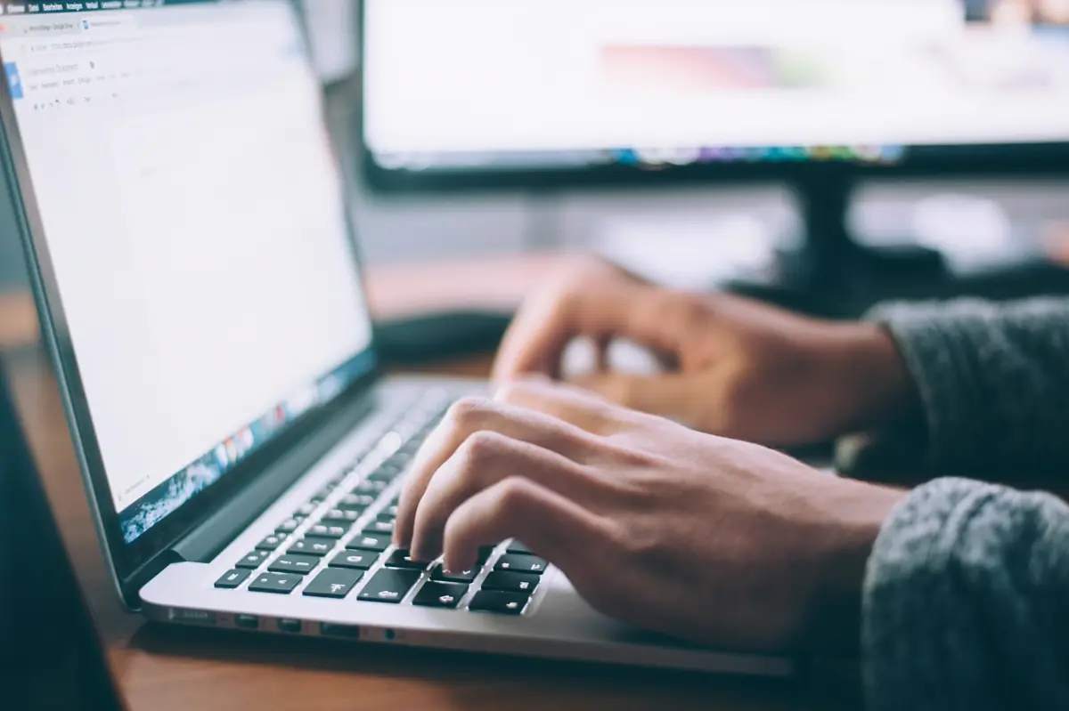 Hände tippen auf einer Laptop-Tastatur — das Coaching läuft auf Wunsch komplett online
